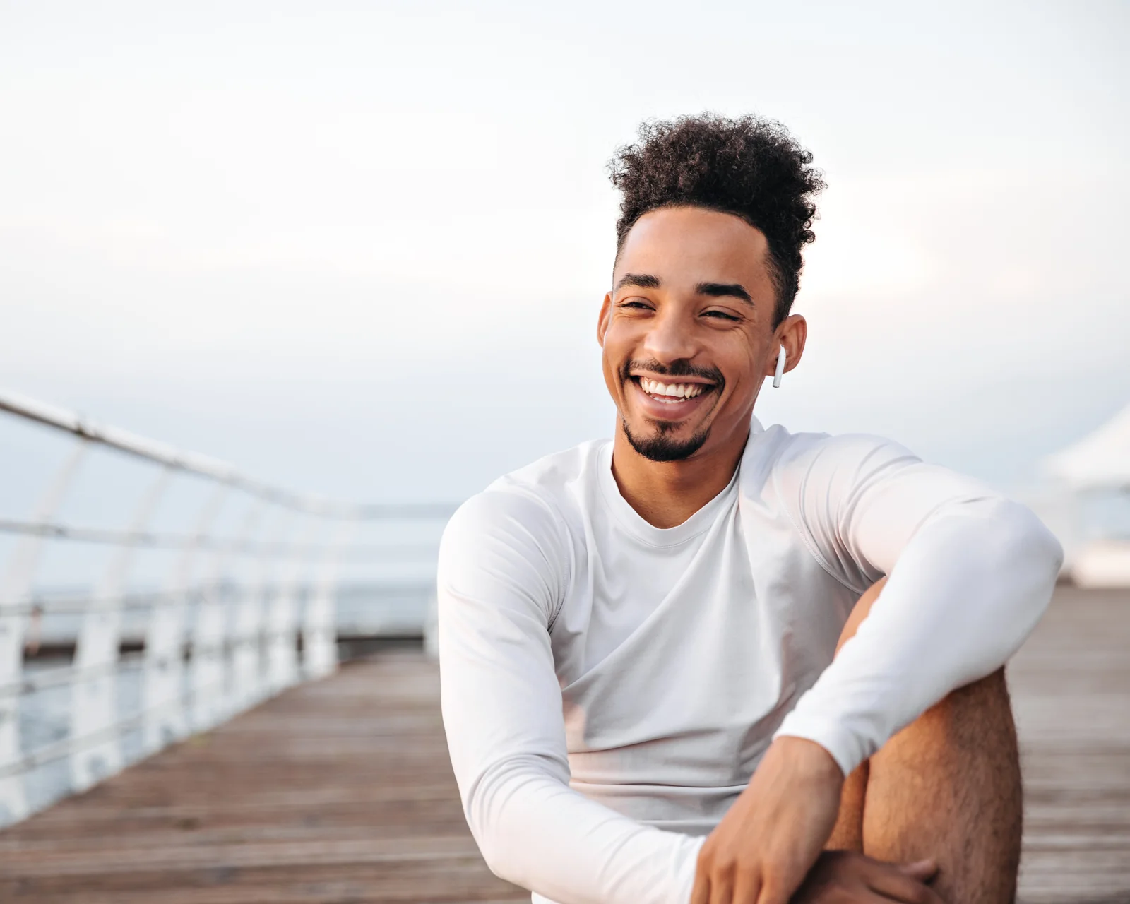 Smiling man relaxing on a waterfront boardwalk