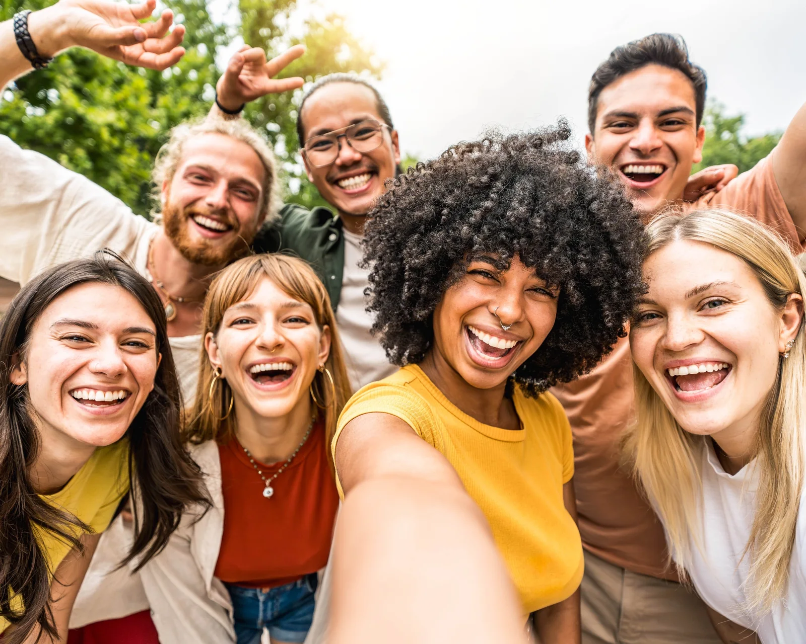 Group of smiling friends taking a selfie outdoors